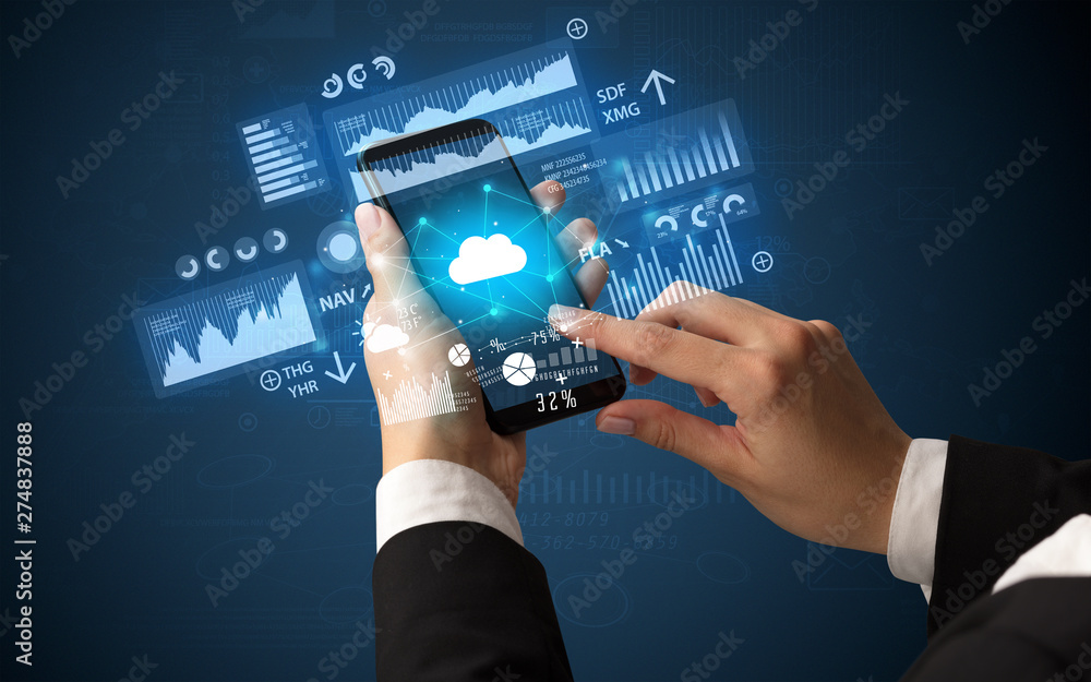 Female hand using smartphone with financial tracking concept illustrated by graphs and symbols Female hand using smartphone with financial tracking concept illustrated by graphs and symbols