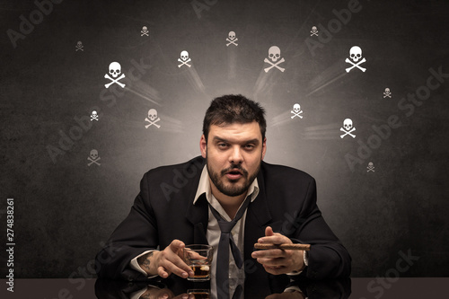 Loser drunk man sitting at table with skulls concept around 