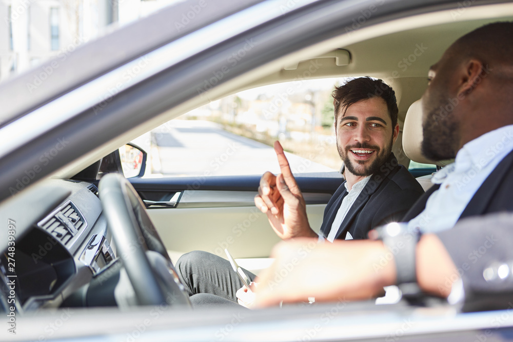 Zwei Geschäftsleute zusammen im Auto unterwegs Zwei Geschäftsleute zusammen im Auto unterwegs