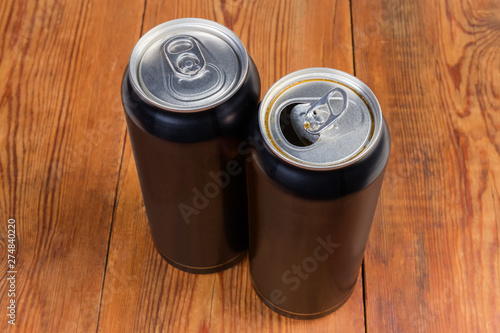 Open and closed black beverage cans on the rustic table