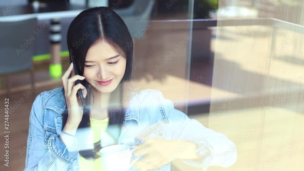Attractive young Asian woman in a uses mobile phone .Business woman talking on the phone, smiling teen speaking on mobile, having conversation on cell Attractive young Asian woman in a uses mobile phone .Business woman talking on the phone, smiling teen speaking on mobile, having conversation on cell