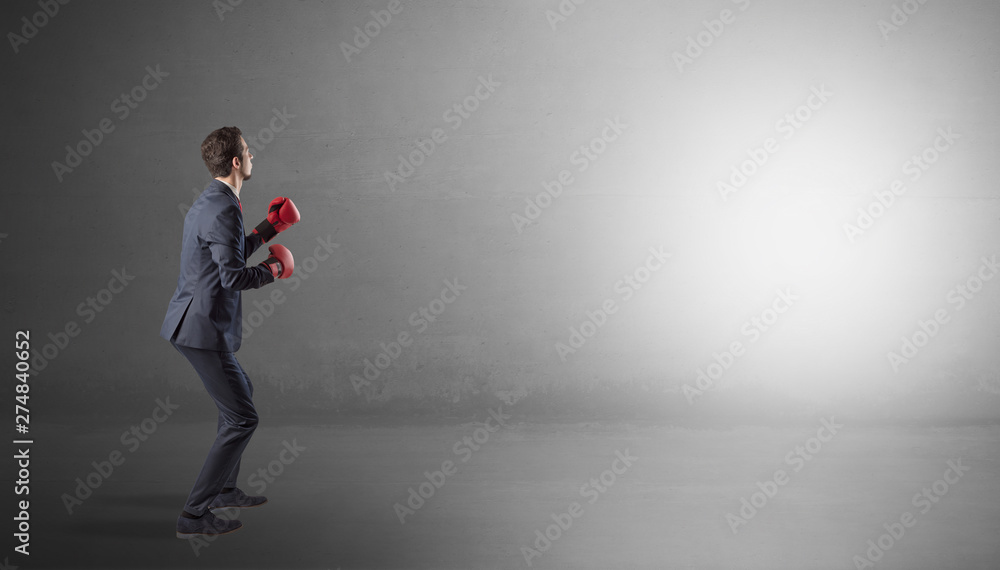 Businessman fighting with boxing gloves in an empty space
Businessman fighting with boxing gloves in an empty space