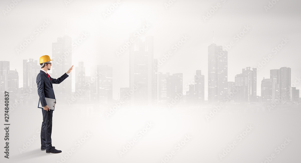 Young supervisor architect standing and looking at a big city panorama
Young supervisor architect standing and looking at a big city panorama