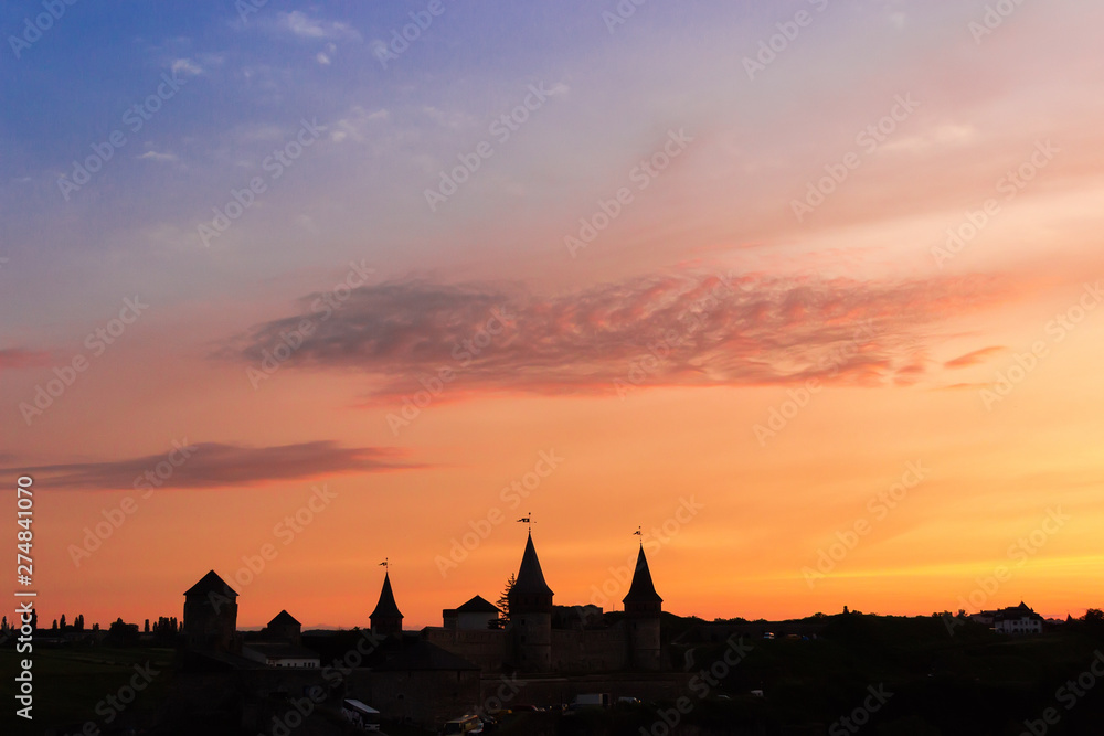 Silhouette of mediaeval fortress in Kamianets-Podilskyi at sunset, Ukraine