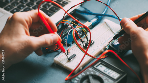 Engeneer workplace. Technician testing microcontroller. Top view of electronic components and wires.