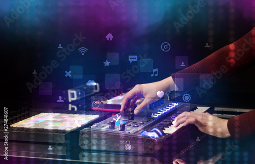 Hand mixing music on dj controller with social media concept icons 