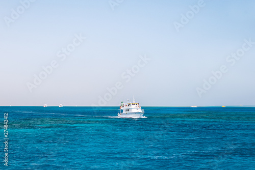 Tourists sailing on a yacht in the Red sea. Boat trip in bright sunny day. Hurghada, Egypt.