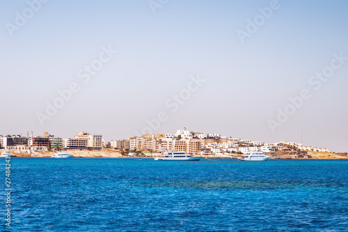 Hurghada coastline with hotel and resort buildings. View on seascape from boat. Red sea, Egypt.