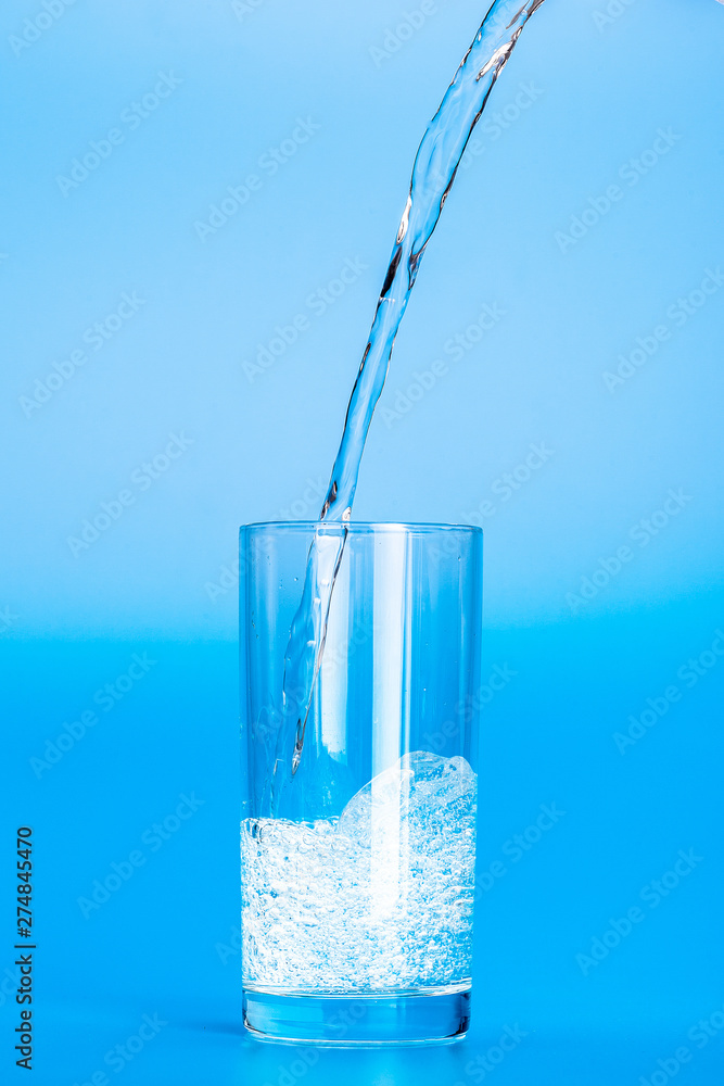 Close up pouring purified fresh drink water from the bottle on table Close up pouring purified fresh drink water from the bottle on table