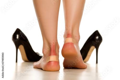 Female heels with blister plaster. Band-aid on cloe up on white background.