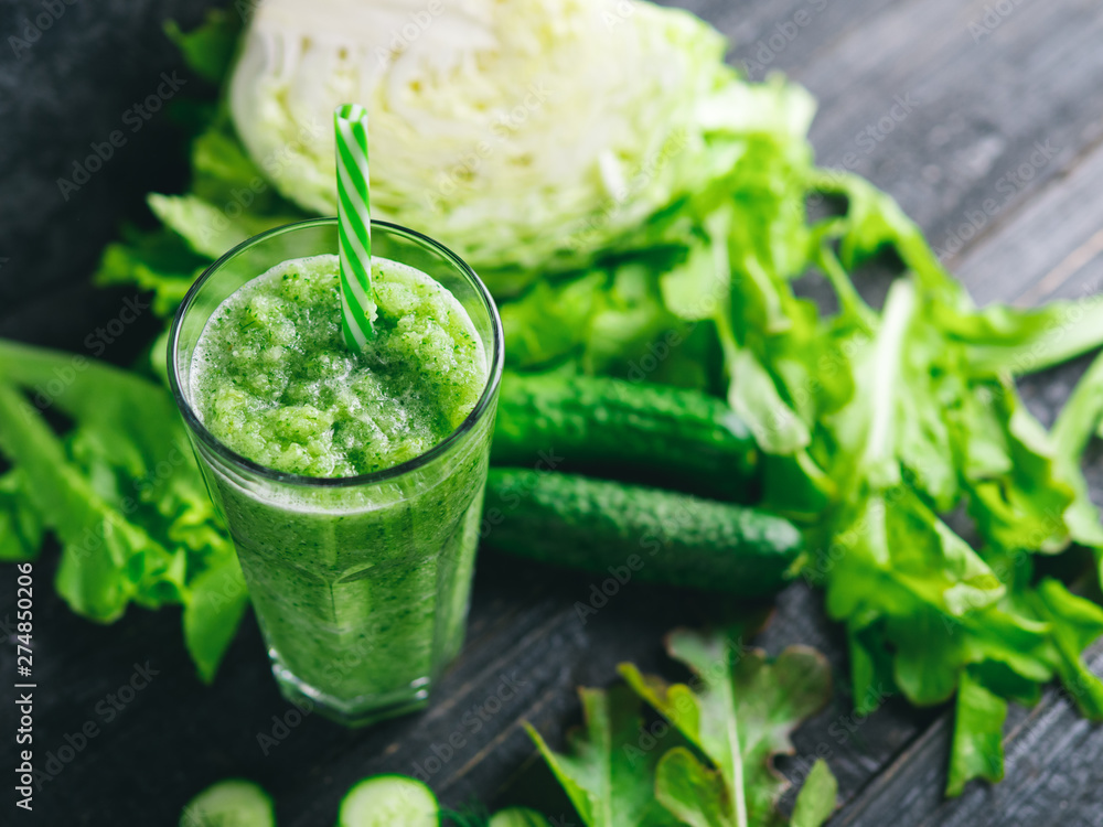 Green smoothie with cucumber, cabbage and healthy greens on the table Green smoothie with cucumber, cabbage and healthy greens on the table