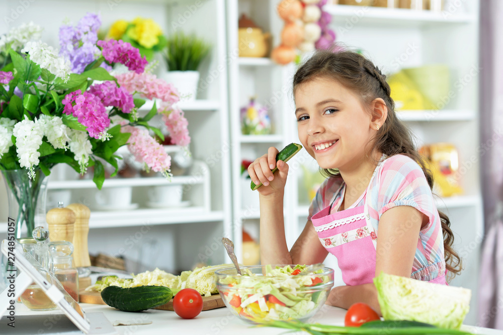 Portrait of cute little girl preparing fresh salad