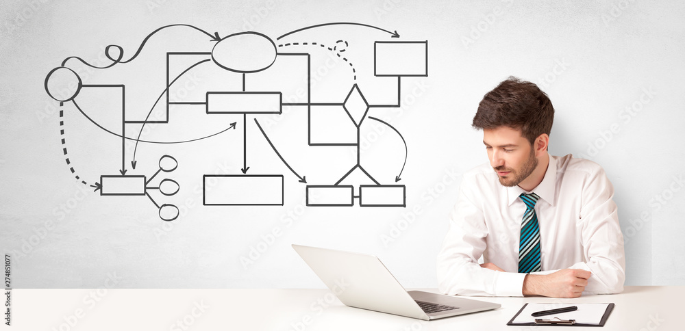Businessman sitting at desk and presenting organizational chart
Businessman sitting at desk and presenting organizational chart