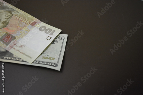 Image of money, Ukrainian money note with an American money note on a brown matte background. One hundred hryvnia and twenty dollars, money and banking market, resources for doing business. Cash accou