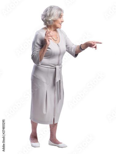 Smiling senior woman pointing on white background