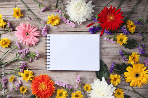 Colorful chrysanthemums placed on the table old wooden with book diary for text