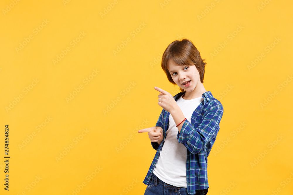 Fun cheerful happy little kid boy in blue shirt white t-shirt posing gesturing hands isolated on yellow wall background children studio portrait. People childhood lifestyle concept. Mock up copy space Fun cheerful happy little kid boy in blue shirt white t-shirt posing gesturing hands isolated on yellow wall background children studio portrait. People childhood lifestyle concept. Mock up copy space