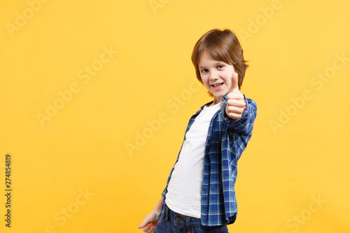 Fun cheerful happy little kid boy in blue shirt white t-shirt posing gesturing hands isolated on yellow wall background children studio portrait. People childhood lifestyle concept. Mock up copy space