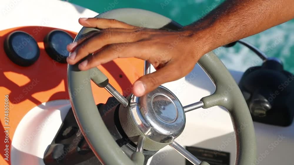 Man controls the boat and steadily turns the steering wheel. Man controls the boat and steadily turns the steering wheel.