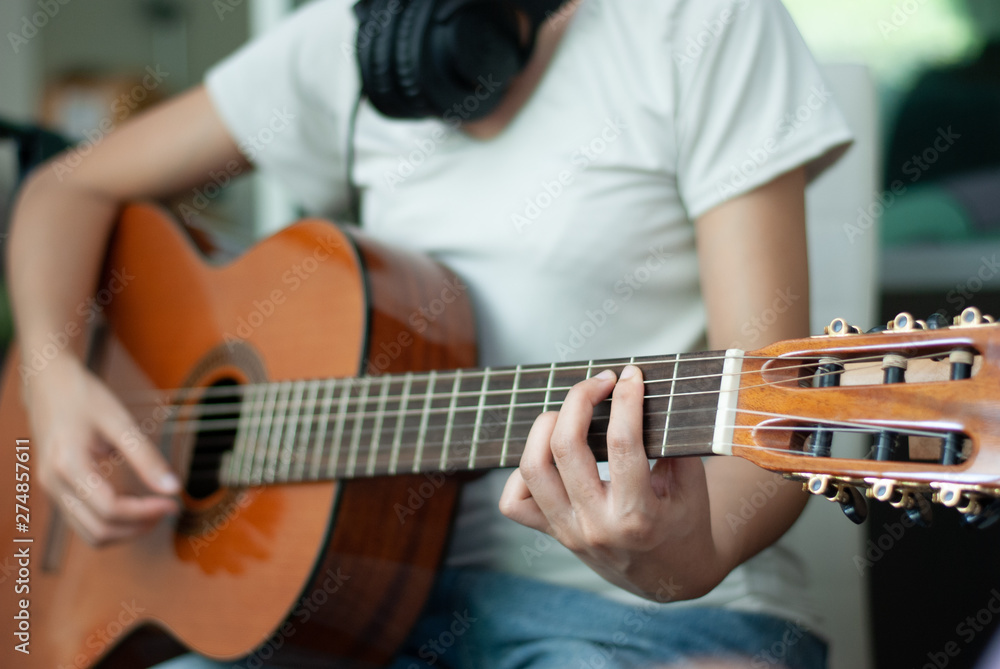 Fototapeta premium woman's hands playing acoustic guitar, close up