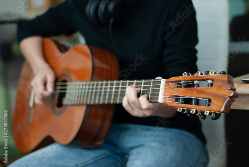 woman's hands playing acoustic guitar, close up