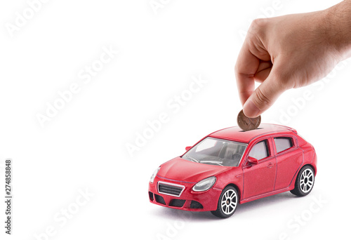 Putting coin into the car coin bank on white background 
