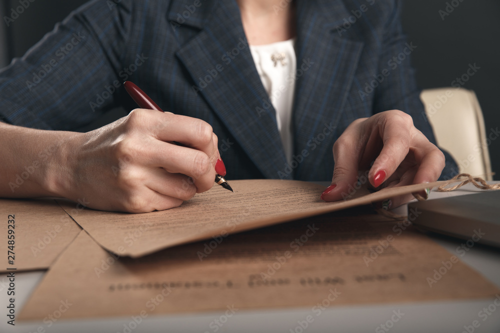 Closeup view of woman attorney writing on documents by pen Closeup view of woman attorney writing on documents by pen