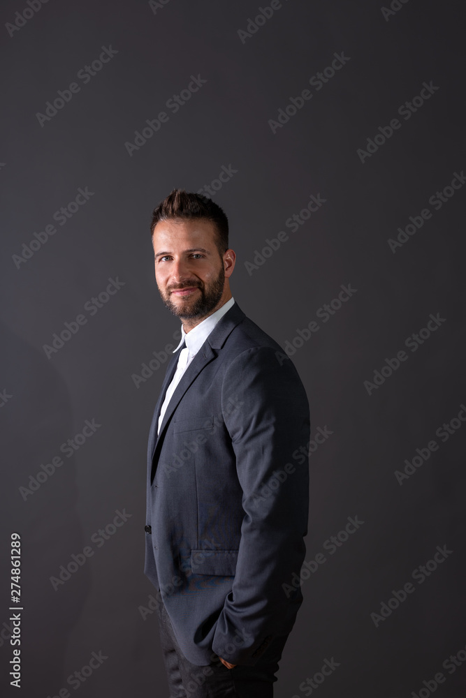 A smiling businessman standing in a studio A smiling businessman standing in a studio