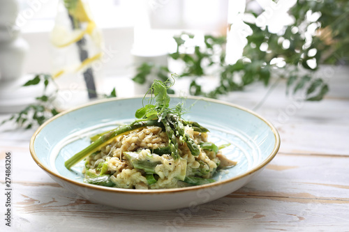 Risotto with spinach and green asparagus. Appetizing dish photo