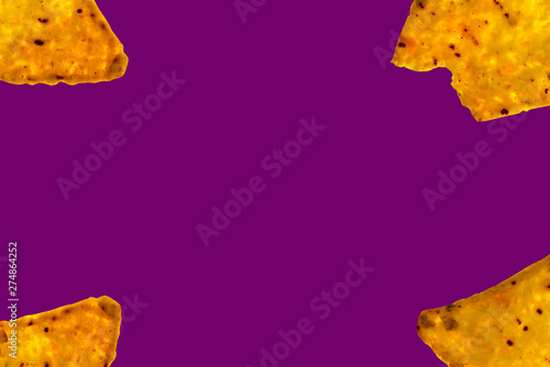 Background of bitten triangular nachos on violet color with an empty space in the center