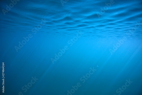 ocean water blue background underwater rays sun / abstract blue background nature water