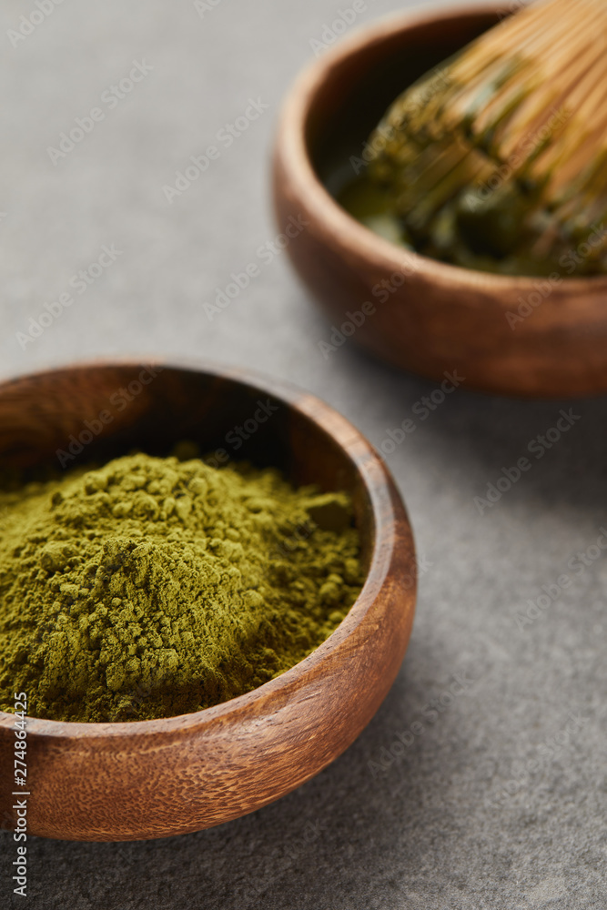 selective focus of green matcha powder and bamboo whisk in wooden bowl selective focus of green matcha powder and bamboo whisk in wooden bowl