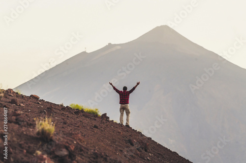 Canvas Print Hiker people man standing in front of a high mountain in background - concept of