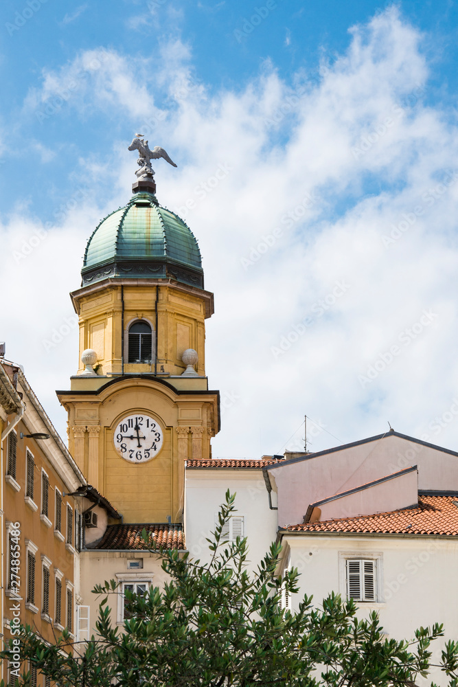 yellow tower with clock and white houses in Rijeka, Istria, Croatia yellow tower with clock and white houses in Rijeka, Istria, Croatia