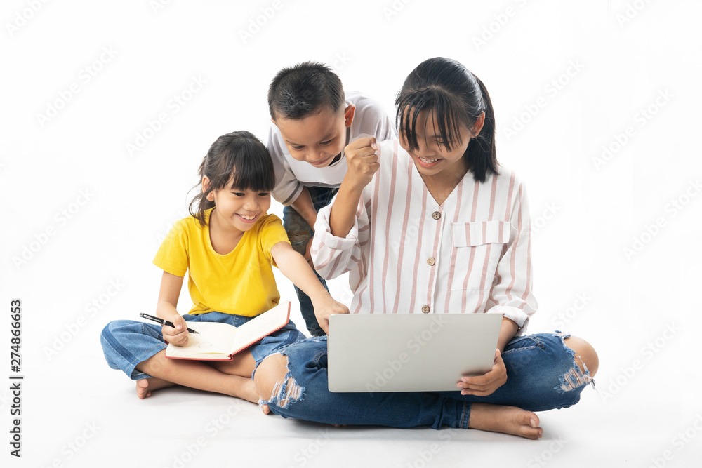 young Asian Thai  kids, boy and girl learning and  looking on laptop by technology and multimedia, isolated  and white background