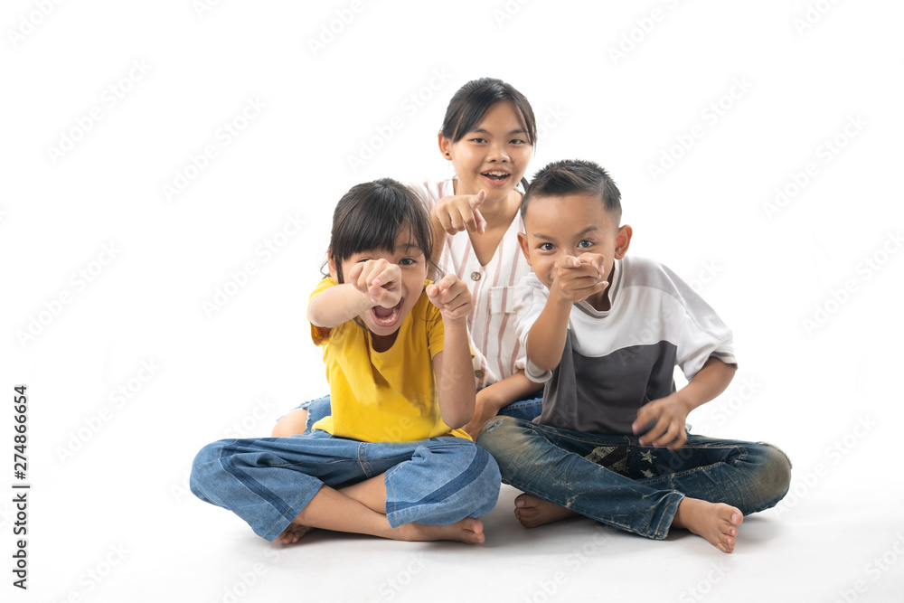 portrait of funny Asian Thai cute kids sitting pointing isolated on white background portrait of funny Asian Thai cute kids sitting pointing isolated on white background
