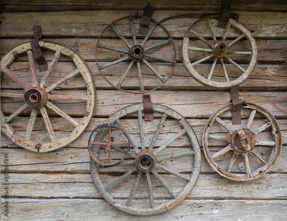 Wooden wheels from an ancient cart hanging on the wall of the hut