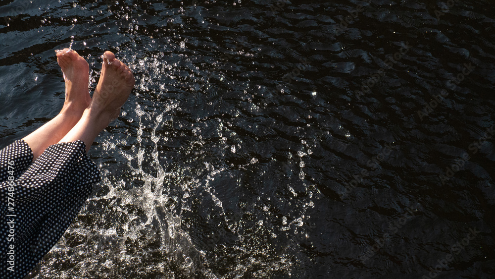 Womens legs throw water. Splash, summer mood