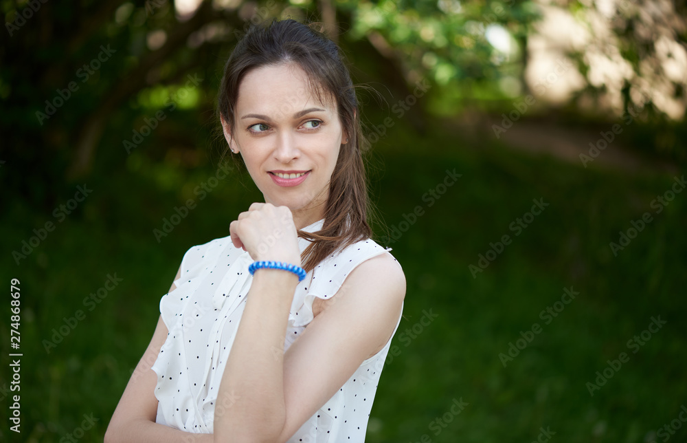Pretty woman is looking away and smiling in the park Pretty woman is looking away and smiling in the park