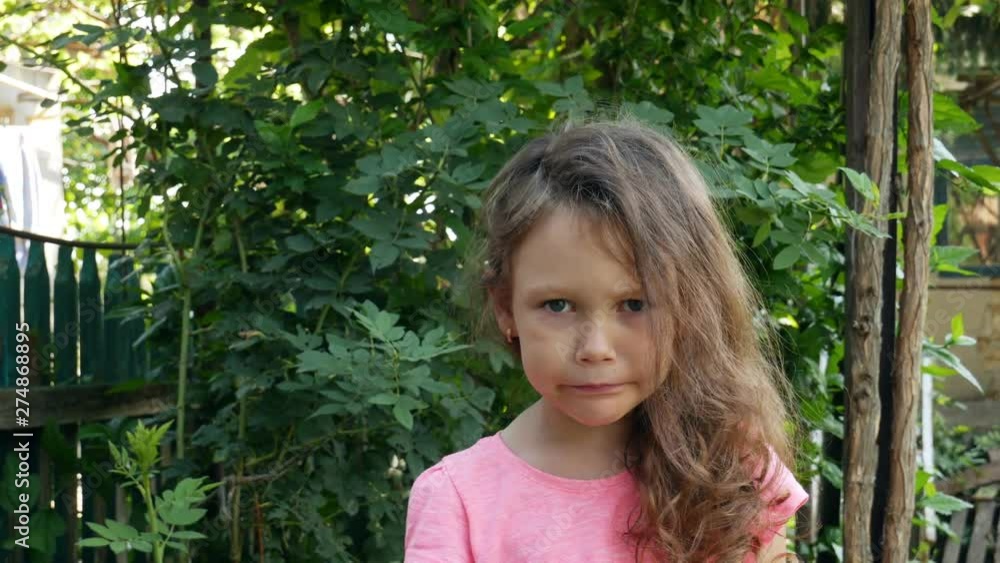 Portrait of a little girl in a rural garden. Portrait of a little girl in a rural garden.