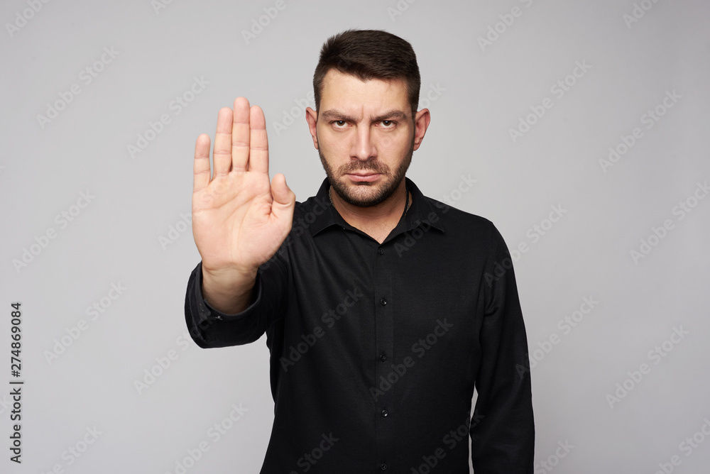 Portrait of a bearded business man showing stop sign Portrait of a bearded business man showing stop sign