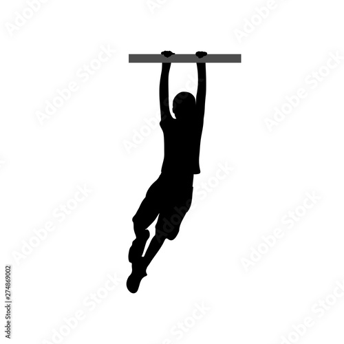 Black silhouette of a boy hanging on the horizontal bar.