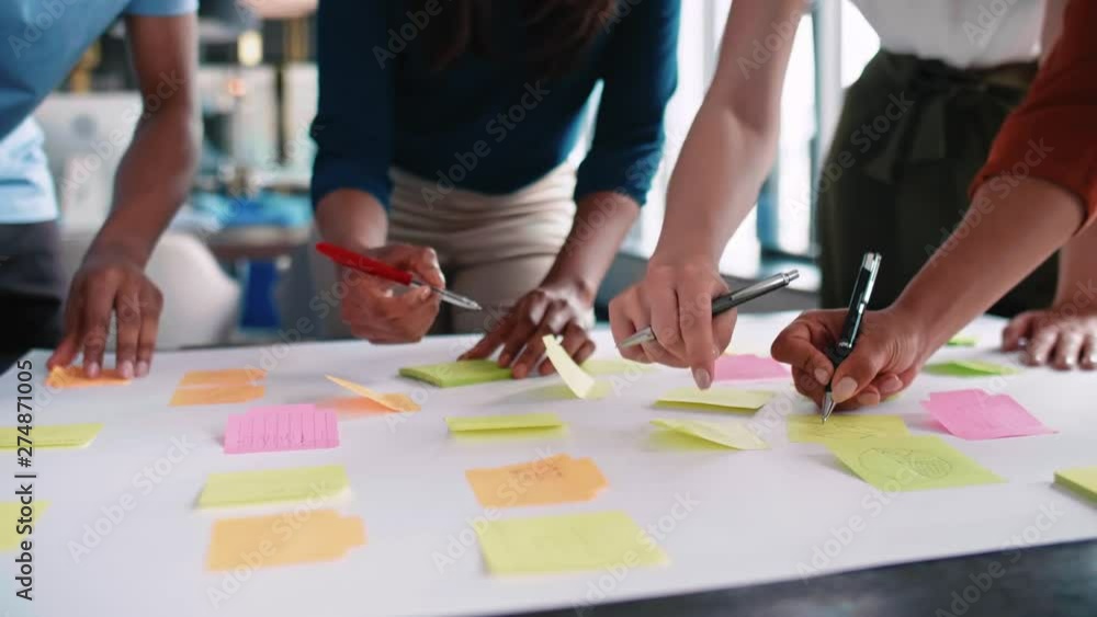 Business people putting ideas on adhesive notes Business people putting ideas on adhesive notes