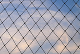 Chain Link Fence With Blue Sky Background.