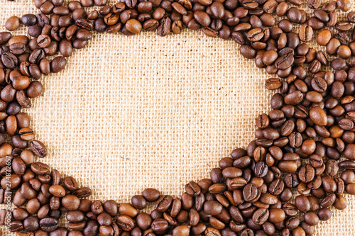 Coffee beans on a background of burlap. Place for text. Concept of making coffee, coffees.