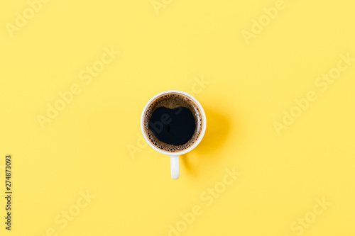 One coffee cup in center of bright yellow background