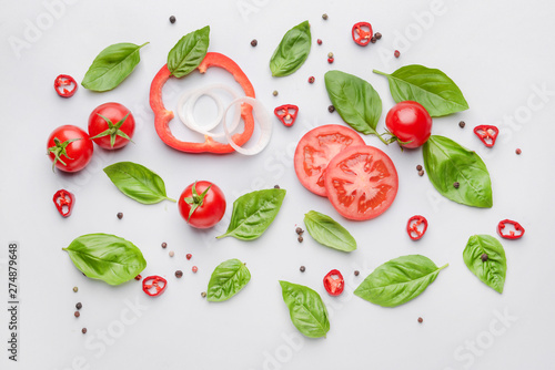 Fresh vegetables and spices on light background
