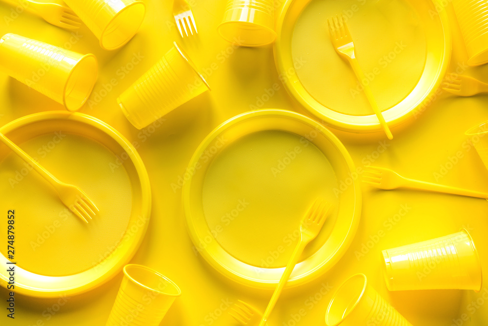Yellow disposable picnic utensils. Environment, eco friendly discarded, plastic, garbage, collection for recycle concept.Top view. Flat lay. Save planet.