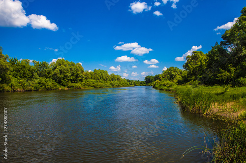 Beautiful scenery. River with trees on the banks. Blue sky with white clouds. Russia. Mordovia.