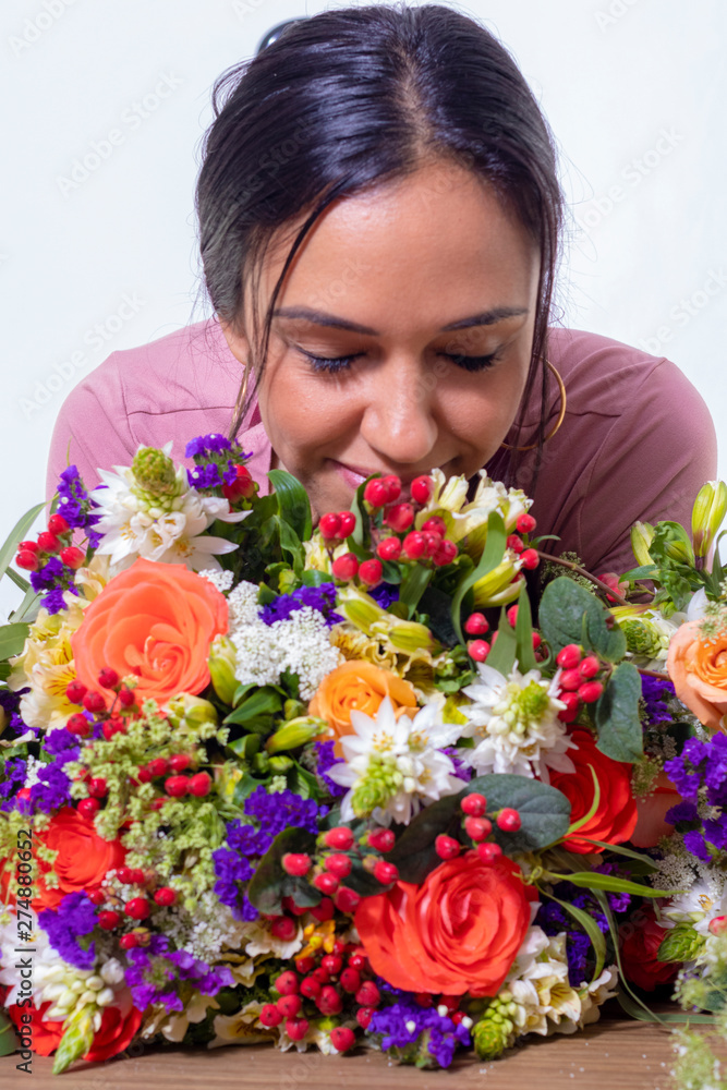 Cute brunette woman enjoying her bouquet of flowers Cute brunette woman enjoying her bouquet of flowers